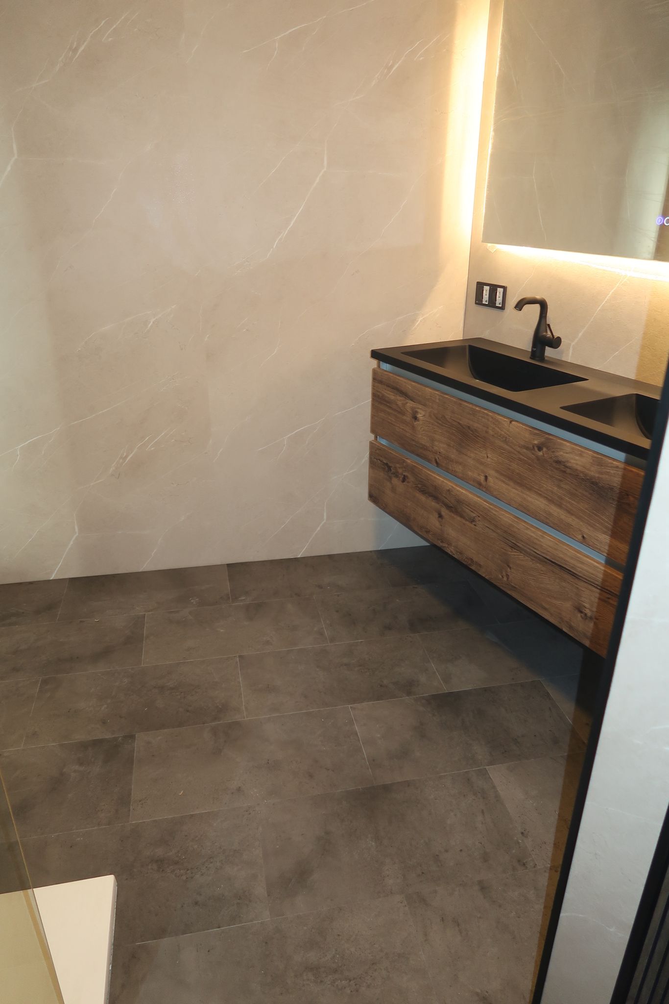 Ruime badkamer met inloopdouche, houten wastafelmeubel en marmerlook tegels